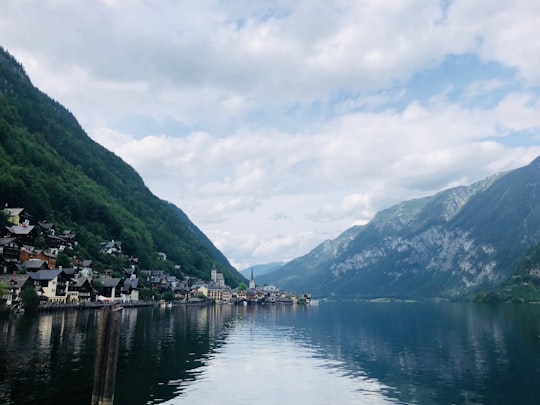 body of water near mountain under cloudy sky during daytime in Bad Goisern Austria