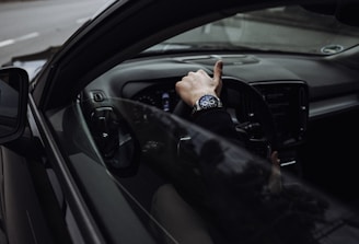 person in black jacket driving car