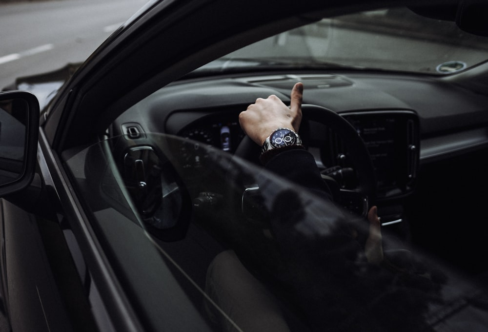 person in black jacket driving car