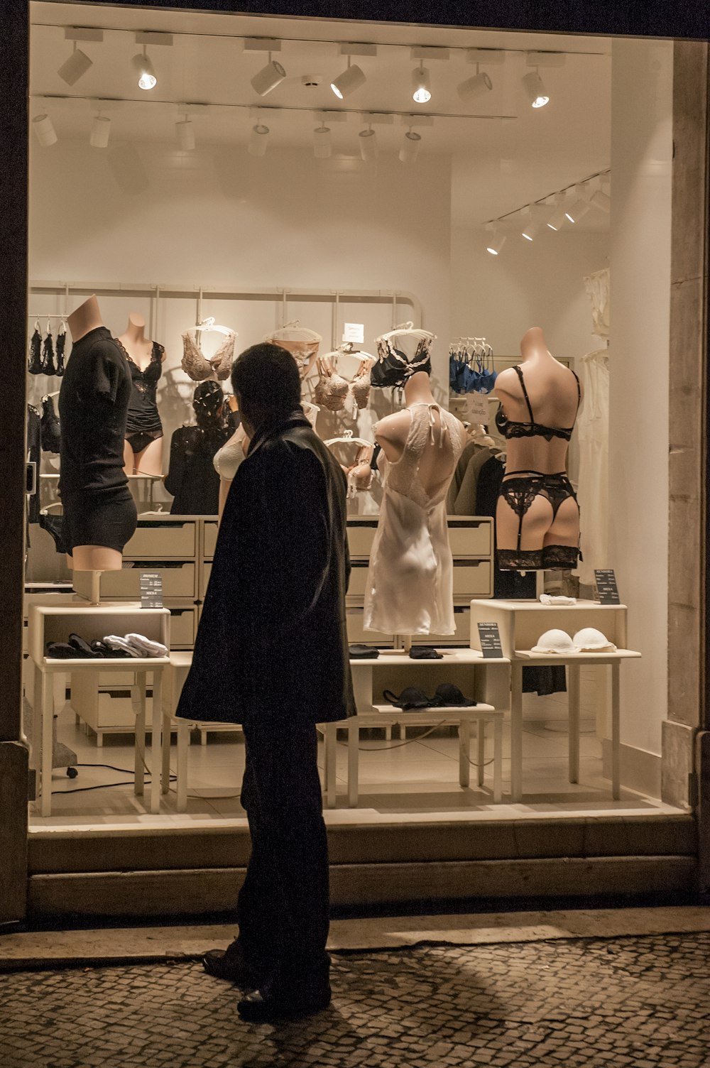 man in black suit standing in front of woman in white dress