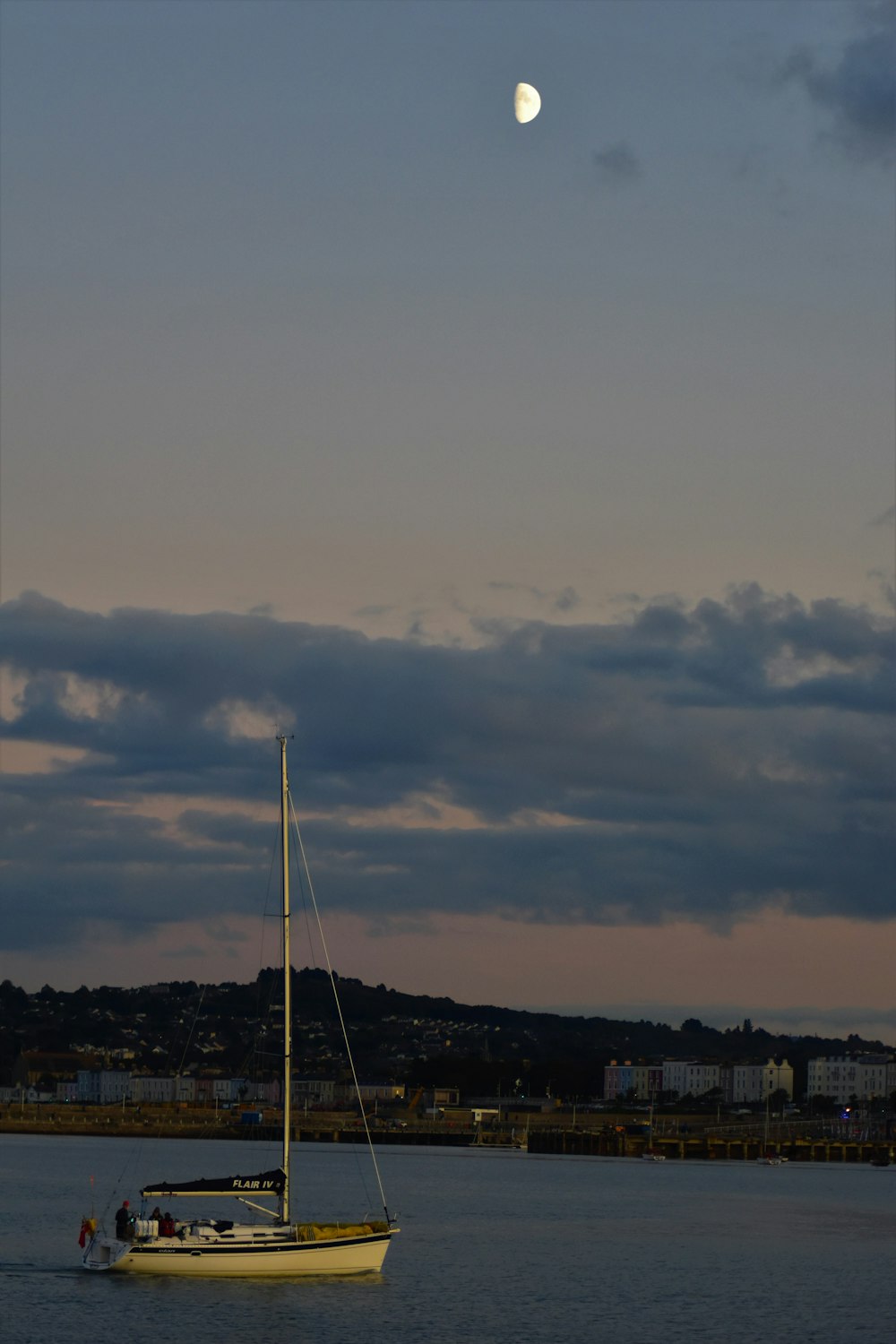 white sailboat on sea under cloudy sky during daytime