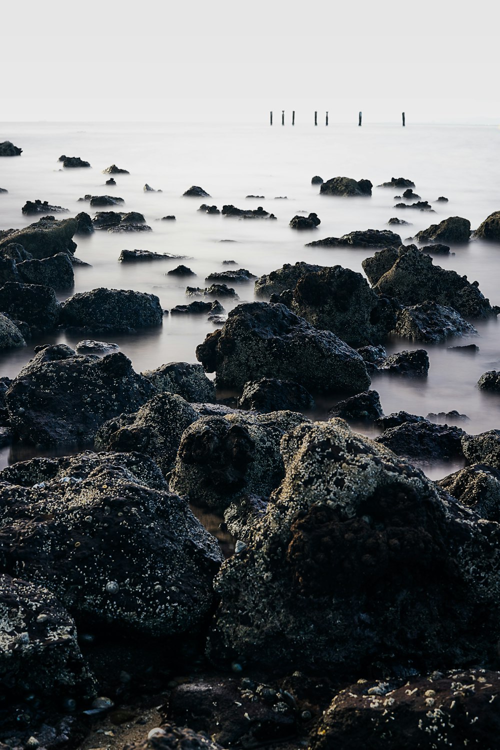 black rock formation on body of water during daytime