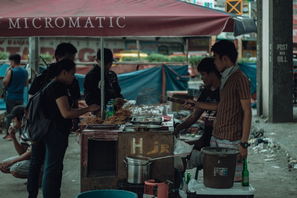 people standing in front of food stall during daytime