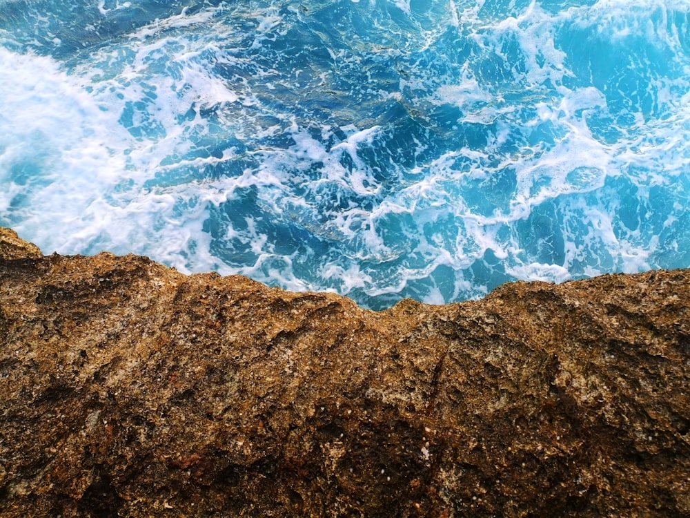 brown rock formation near body of water during daytime