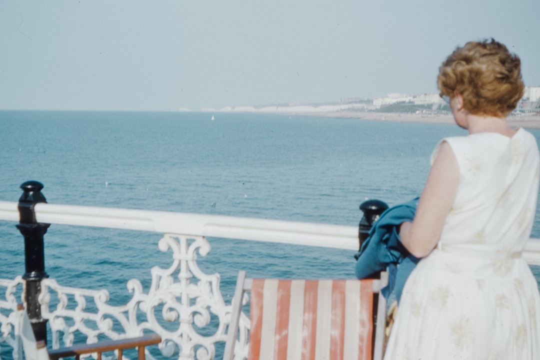 woman in blue and white dress sitting on brown wooden chair