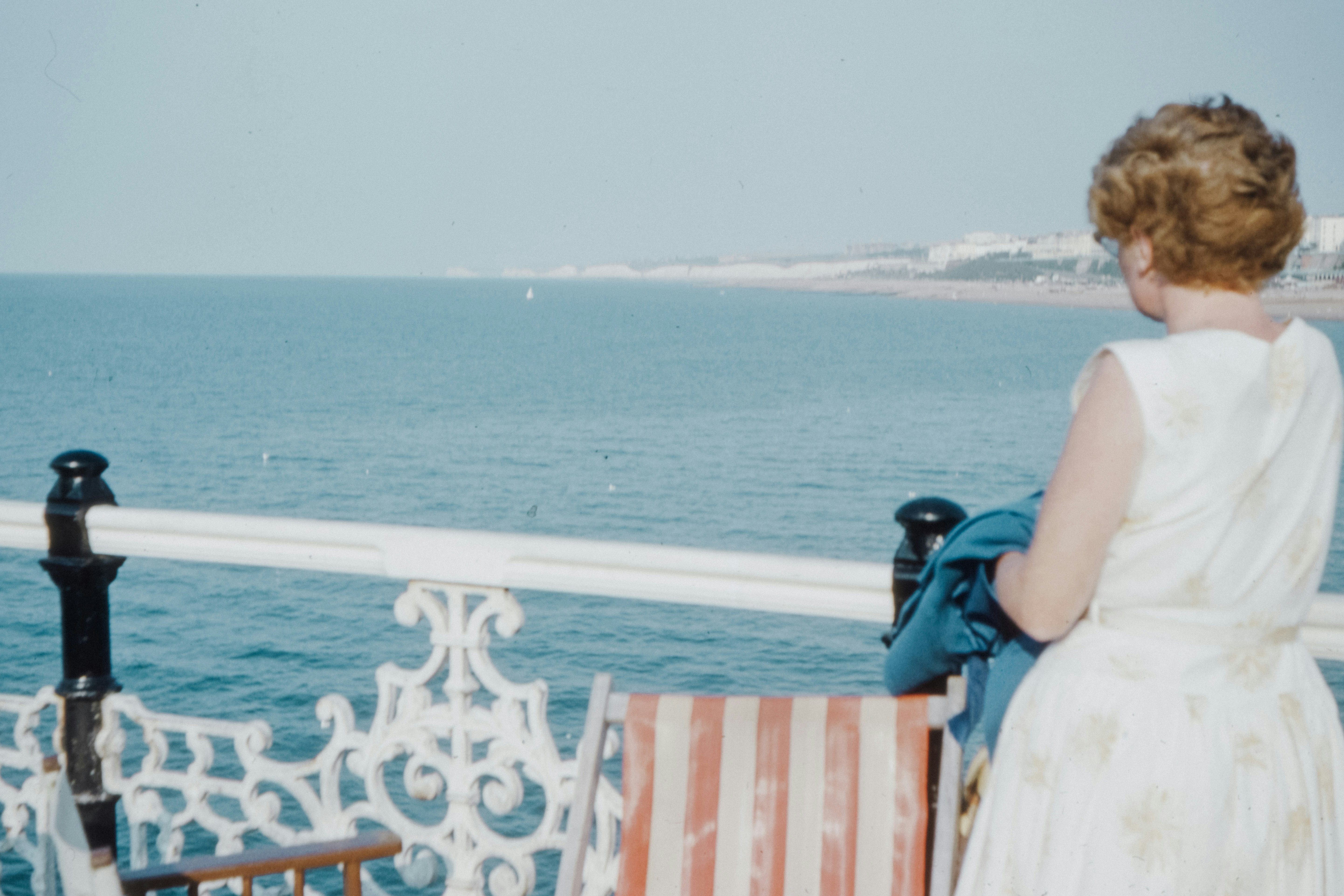 woman in blue and white dress sitting on brown wooden chair