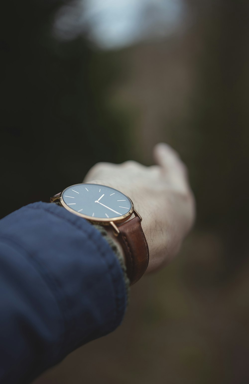 person wearing gold analog watch