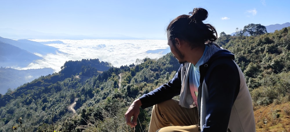 woman in black long sleeve shirt sitting on brown chair looking at the mountains during daytime