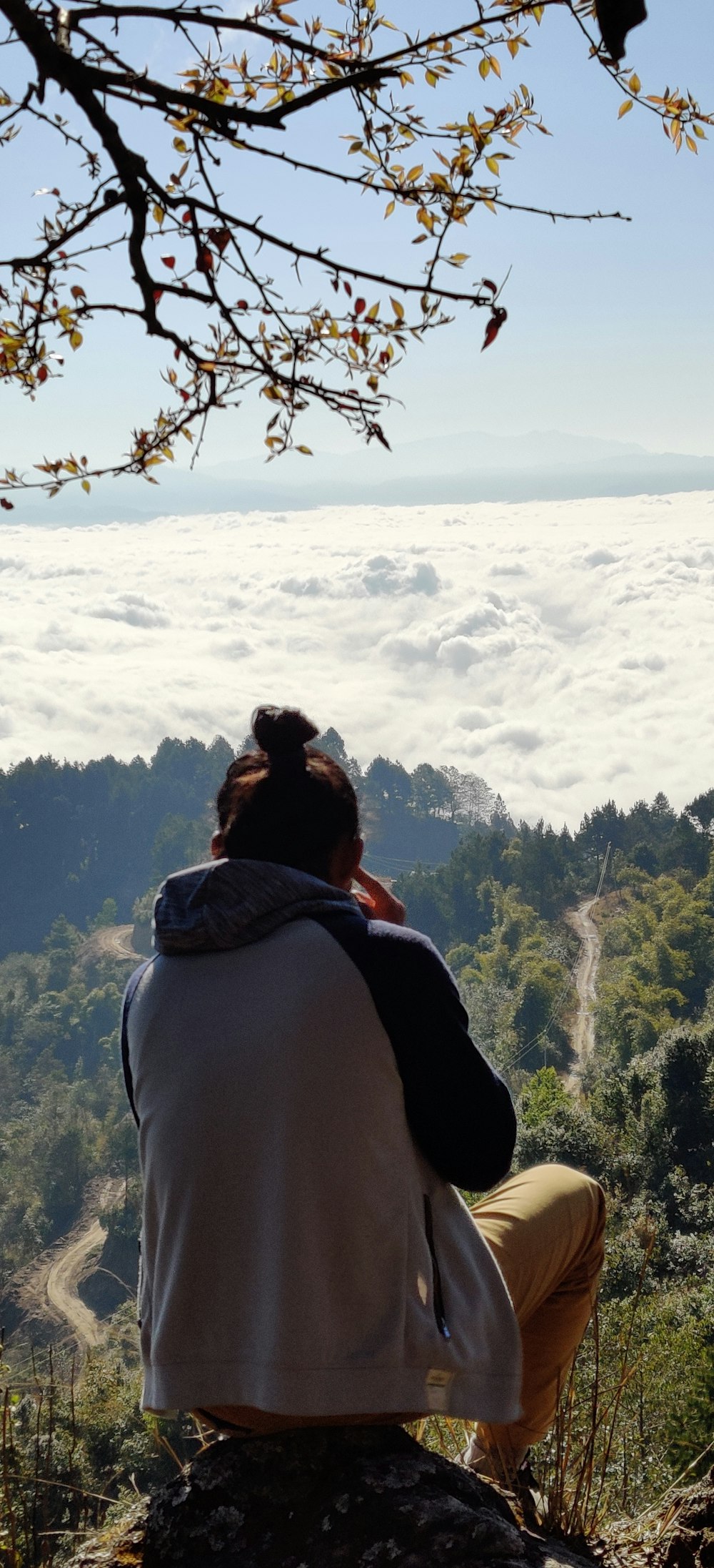 woman in gray hoodie standing on mountain top during daytime