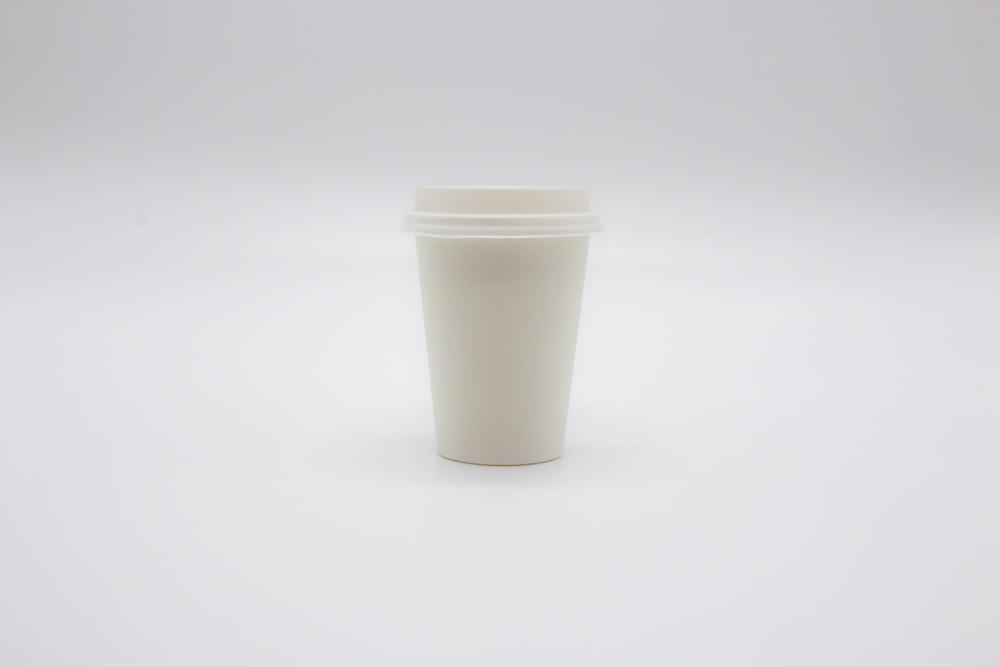 white disposable cup on white table