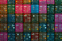 Close-up of stacked shipping containers with vibrant colors, highlighting organized logistics.