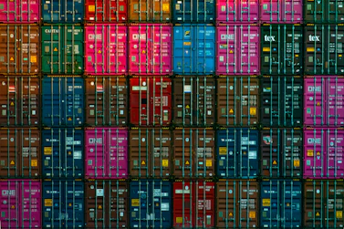 A vibrant, colorful collage showing global trade connections between Europe and Africa with shipping containers and handshake.