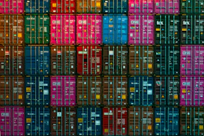 Stacked shipping containers in vibrant colors ready for transport at Sharjah port.