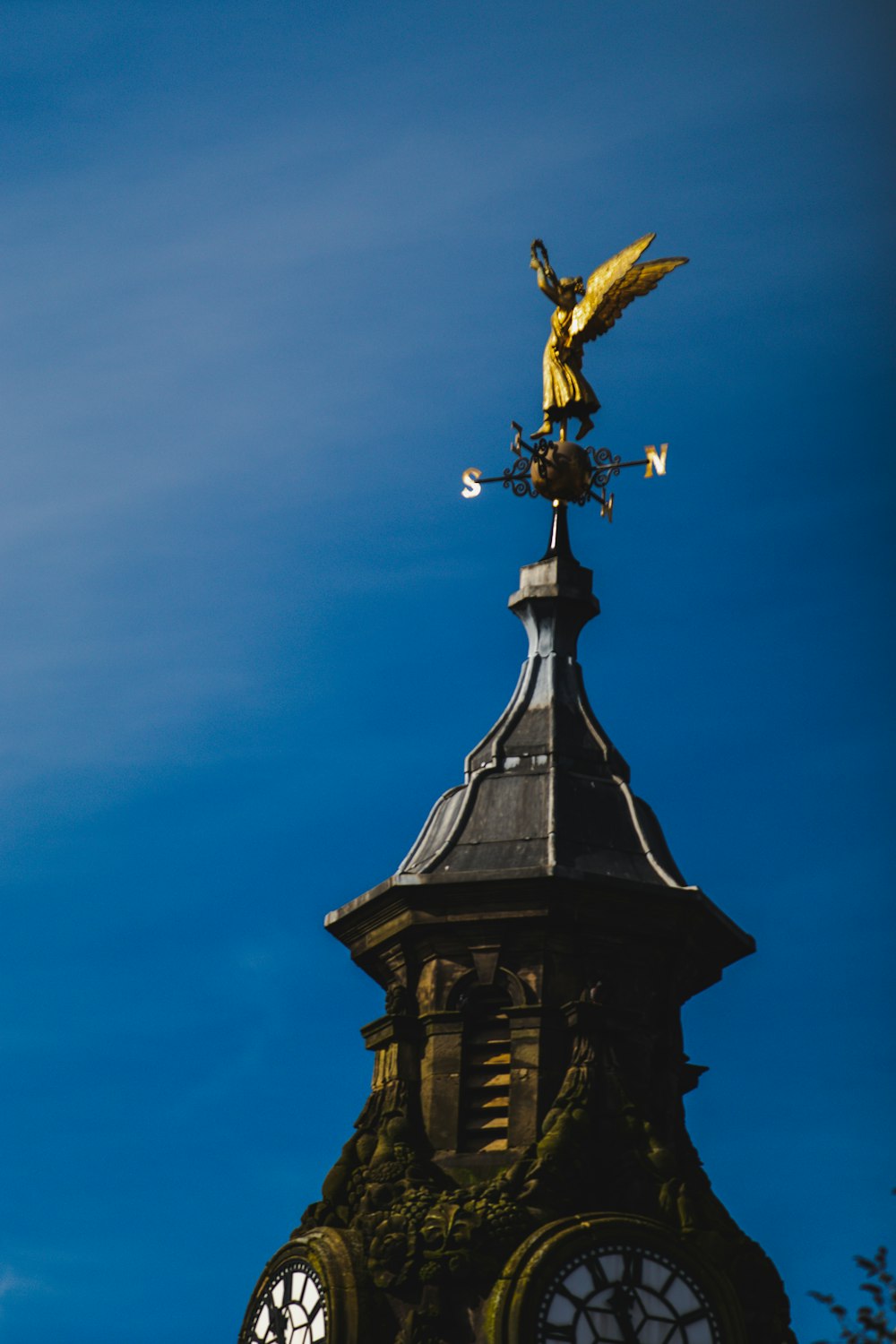 gold angel on top of black tower