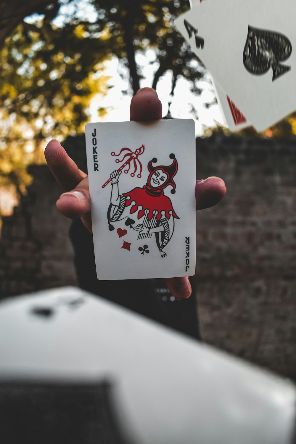joker playing card on persons hand
