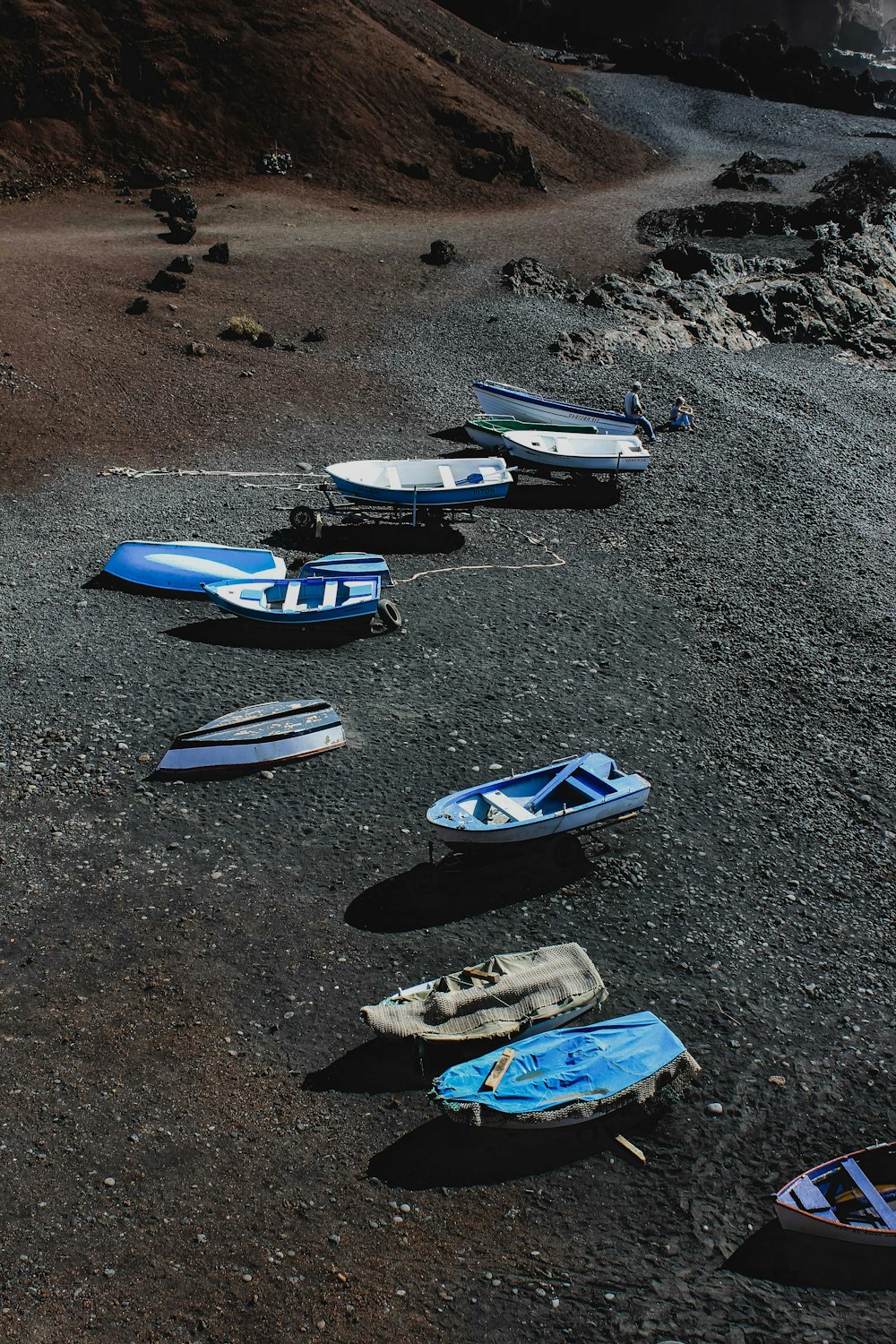 blue and white kayaks on gray sand during daytime