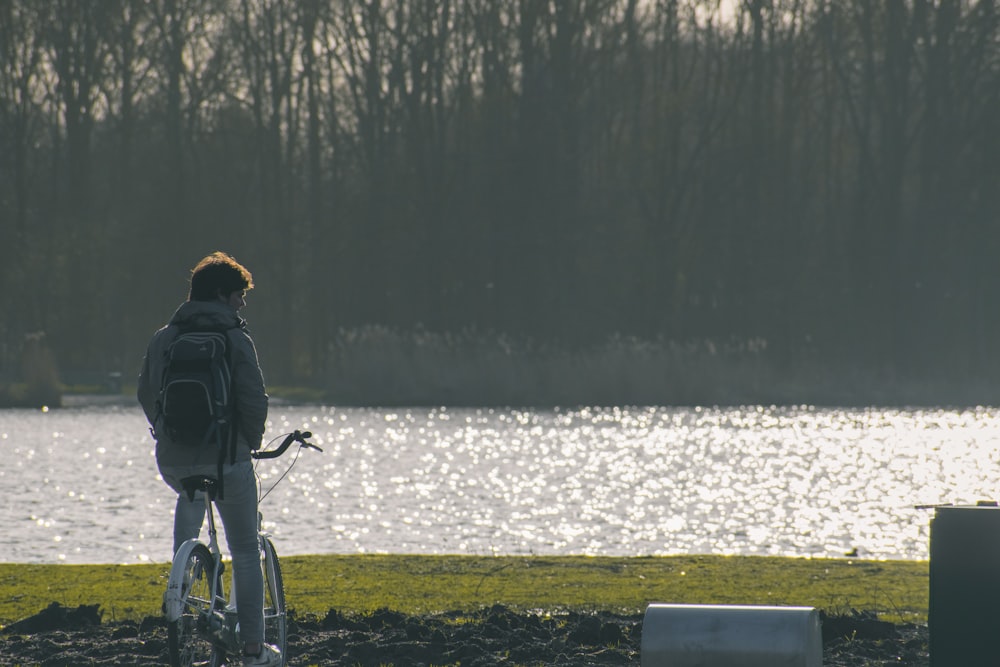 man in black jacket riding bicycle on snow covered ground during daytime