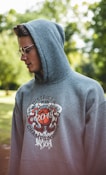 man in gray and red pullover hoodie wearing black framed eyeglasses