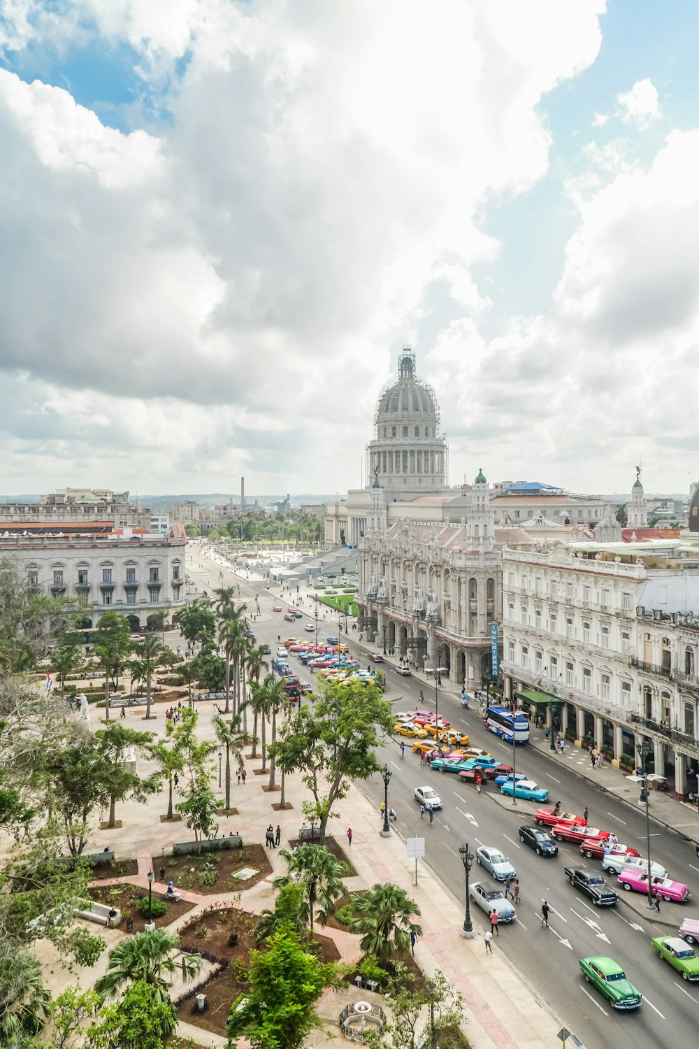 carros estacionados no estacionamento perto de um edifício de concreto branco durante o dia