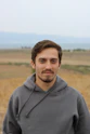 man in gray hoodie standing on field during daytime