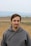 man in gray hoodie standing on field during daytime