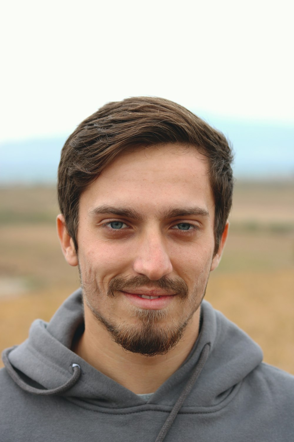 man in gray hoodie smiling