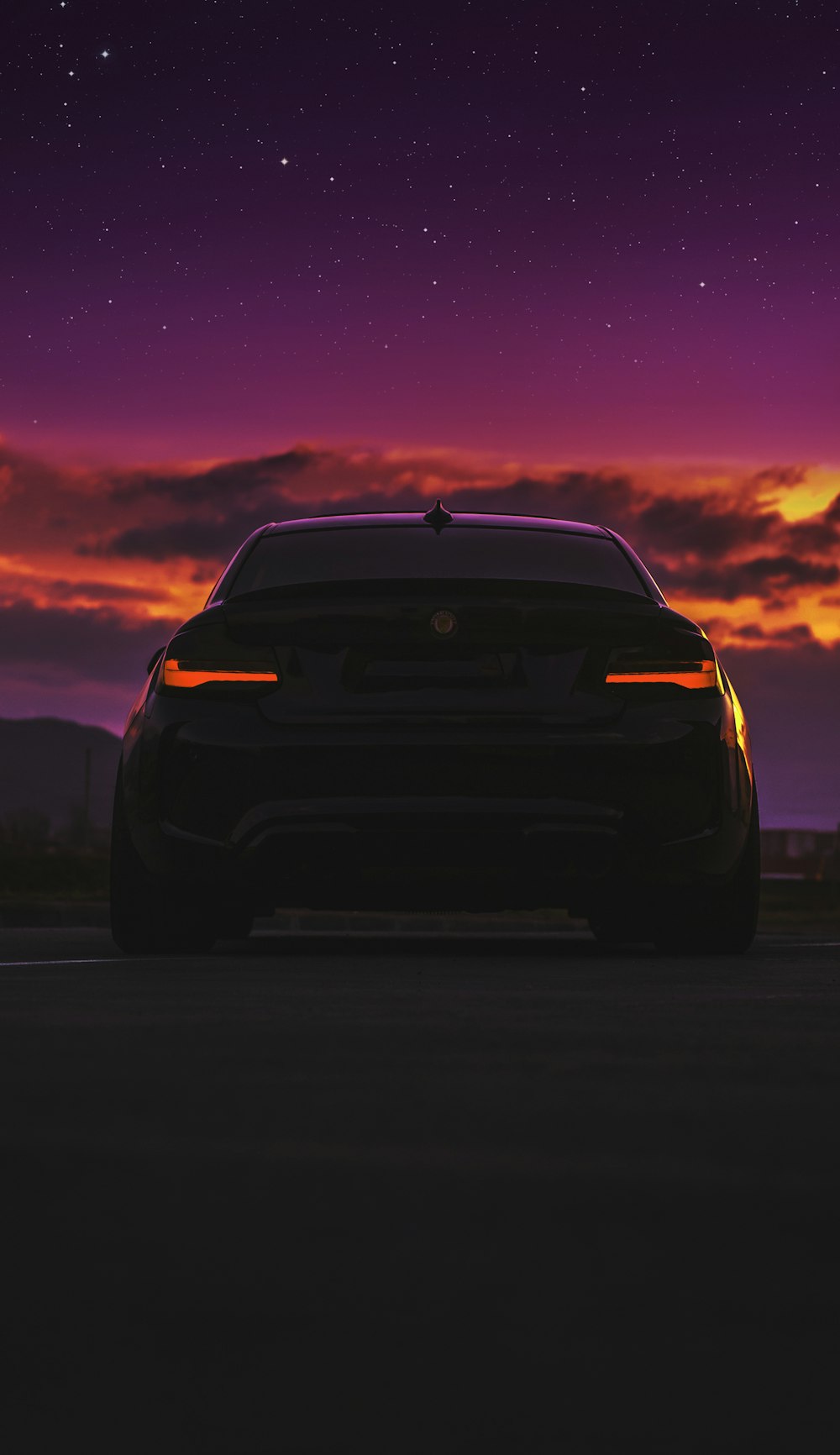 日没時の道路上の黒い車