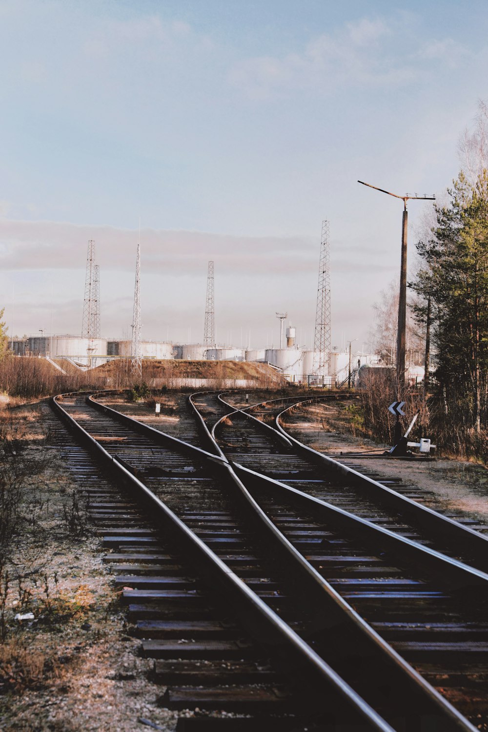 man in black jacket standing on train rail during daytime