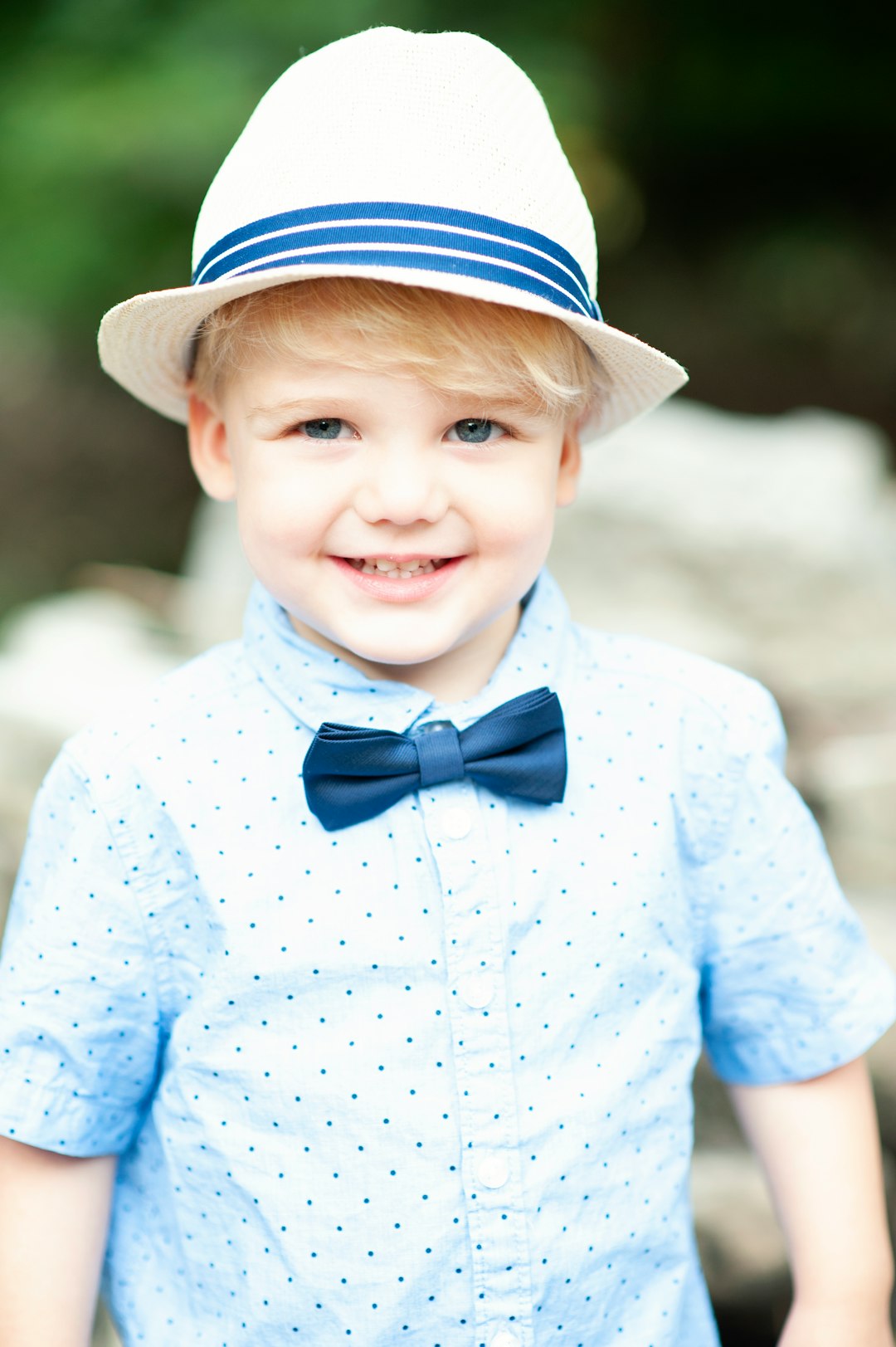 boy in blue and white star print long sleeve shirt smiling