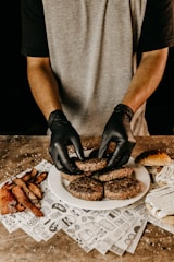 man in gray t-shirt holding black pastry