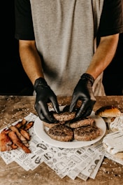 man in gray t-shirt holding black pastry