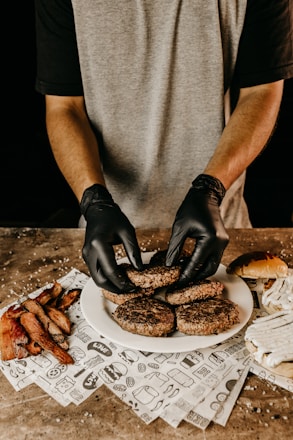 man in gray t-shirt holding black pastry