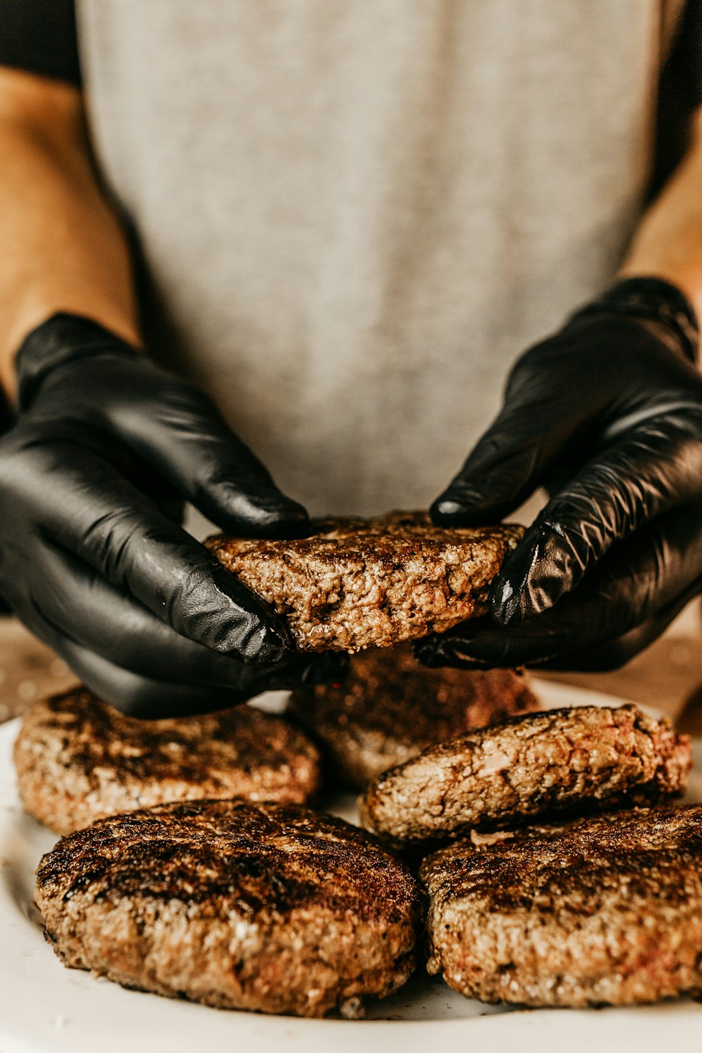 person in black leather gloves holding brown bread