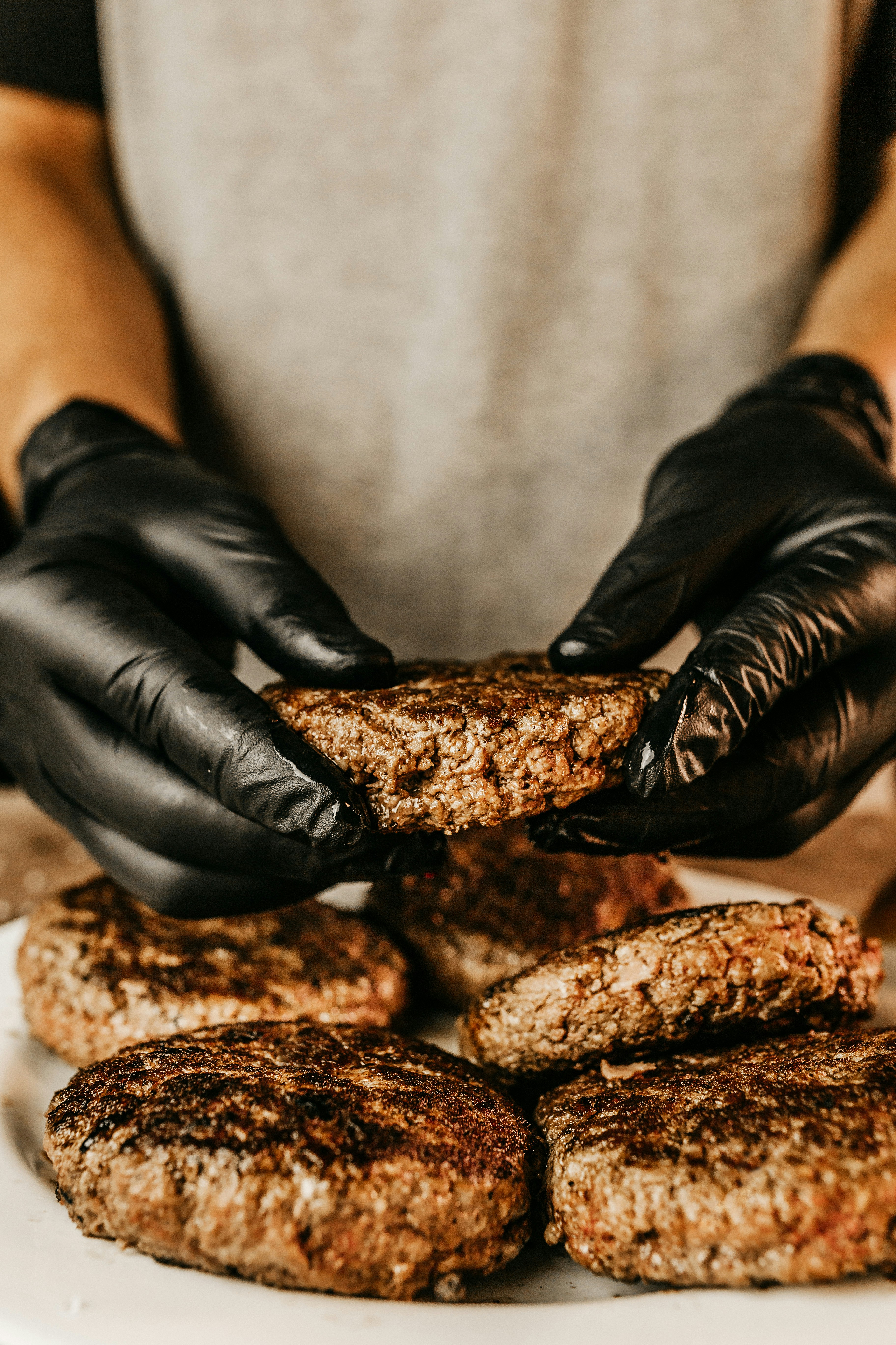 person in black leather gloves holding brown bread