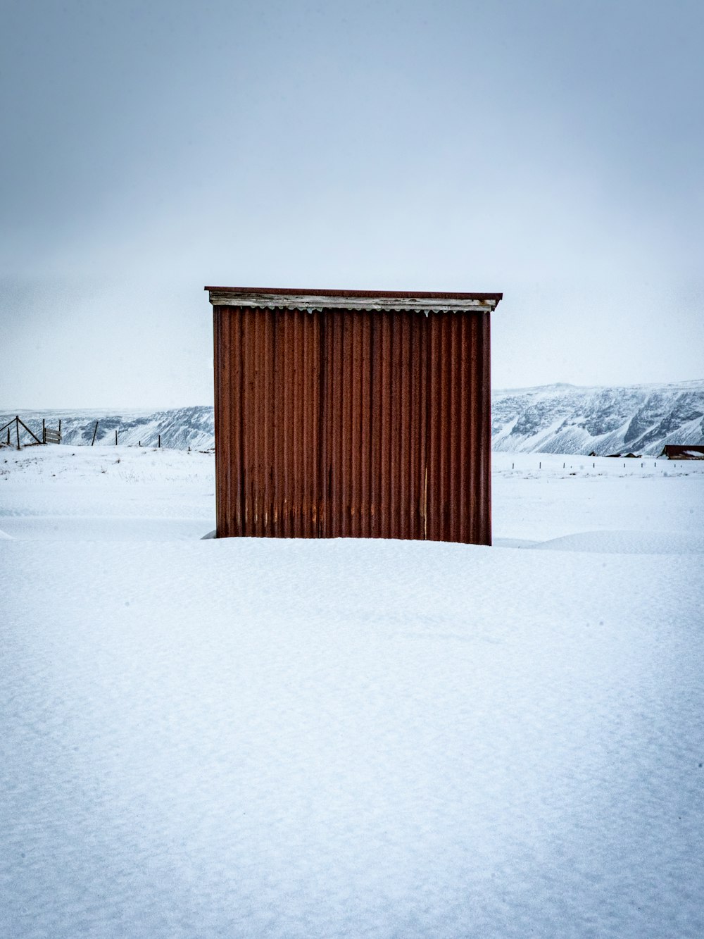 brown wooden house on snow covered ground