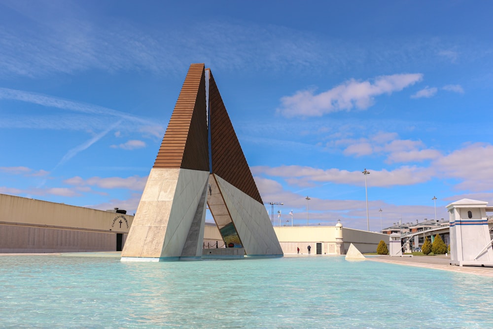 Bâtiment en béton brun et blanc près d’un plan d’eau pendant la journée