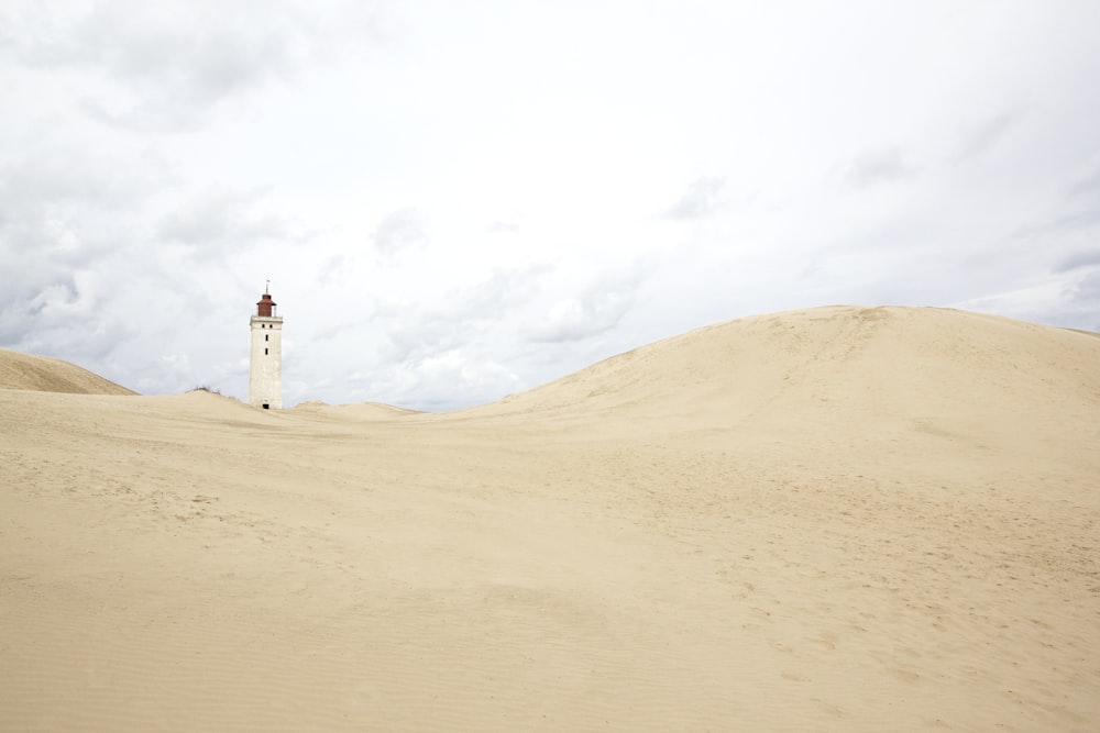 white concrete building on brown sand under white sky during daytime