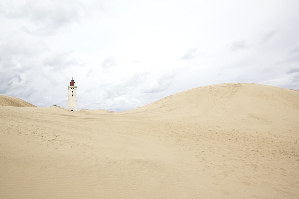 edificio de hormigón blanco sobre arena marrón bajo cielo blanco durante el día