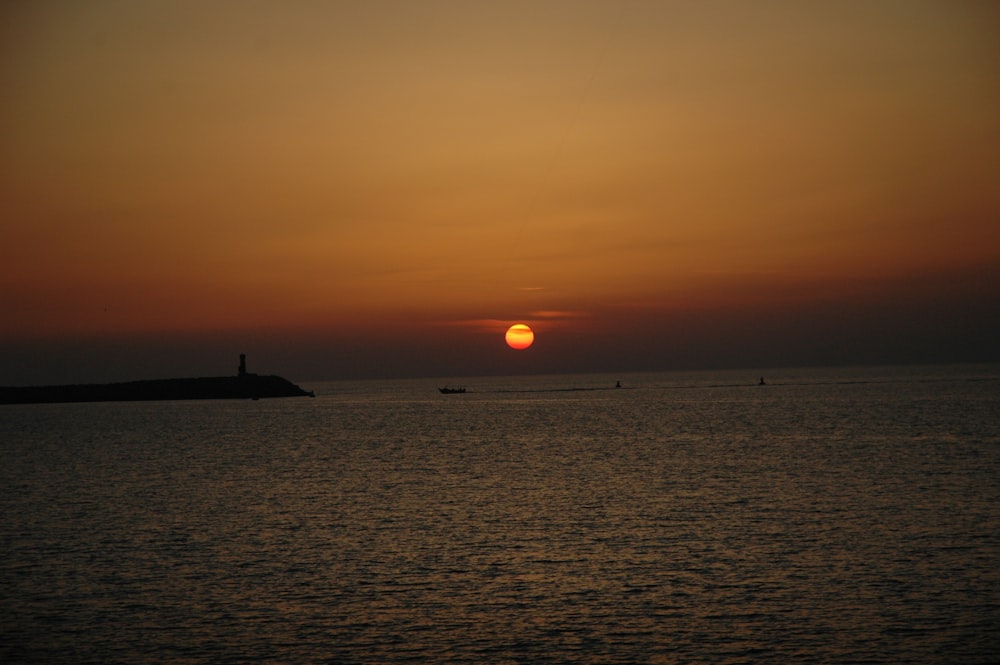 silhouette of a ship on sea during sunset
