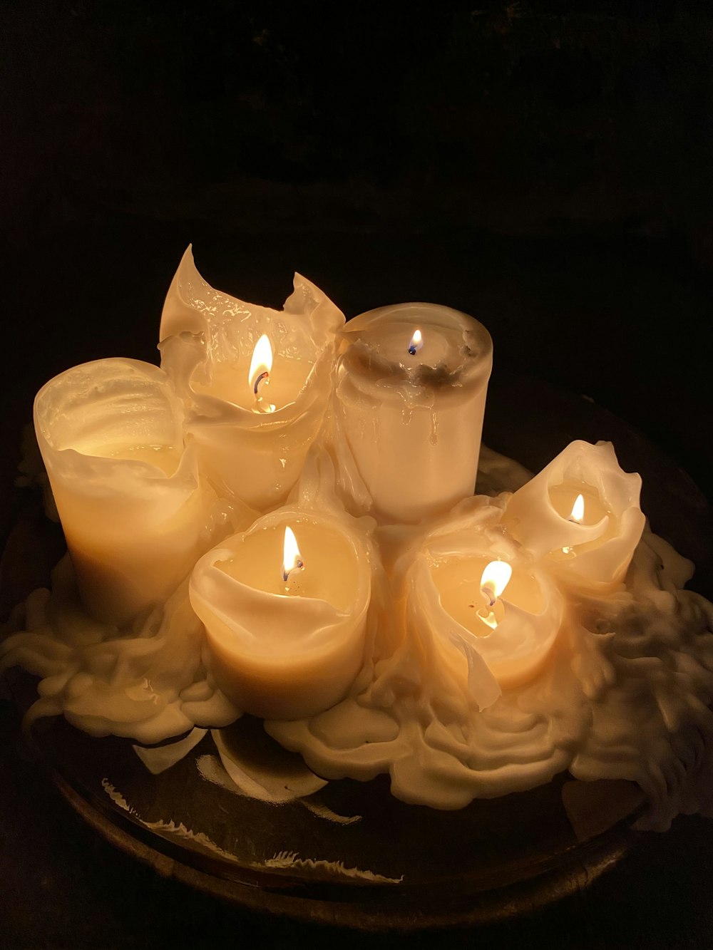 white candles on black surface