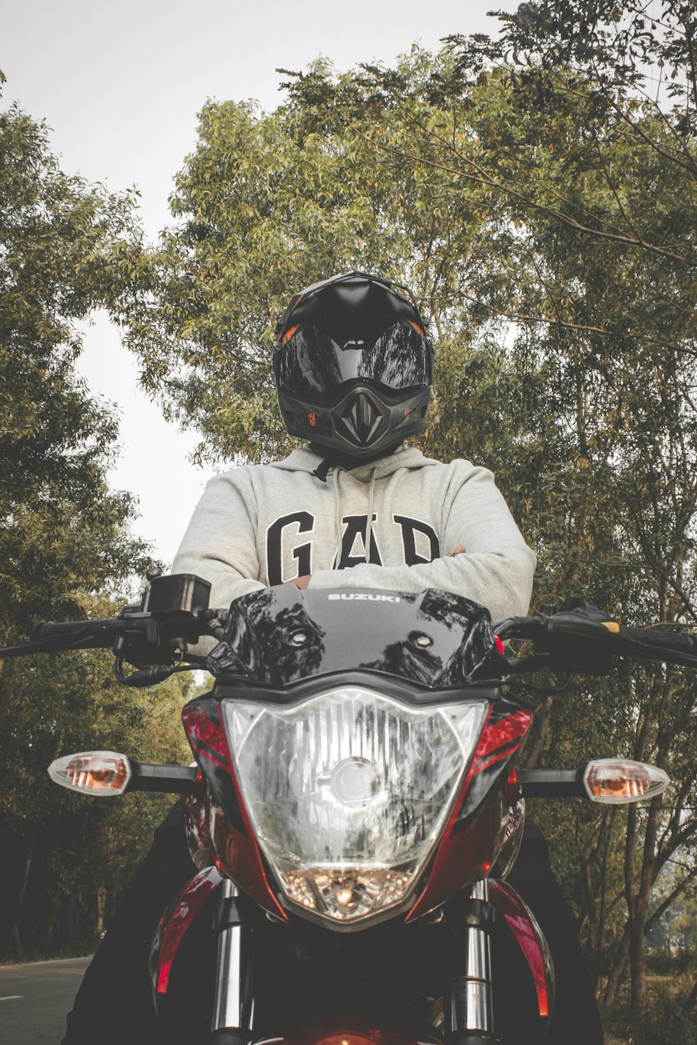man in black and white jacket wearing black helmet riding on black and red sports bike
