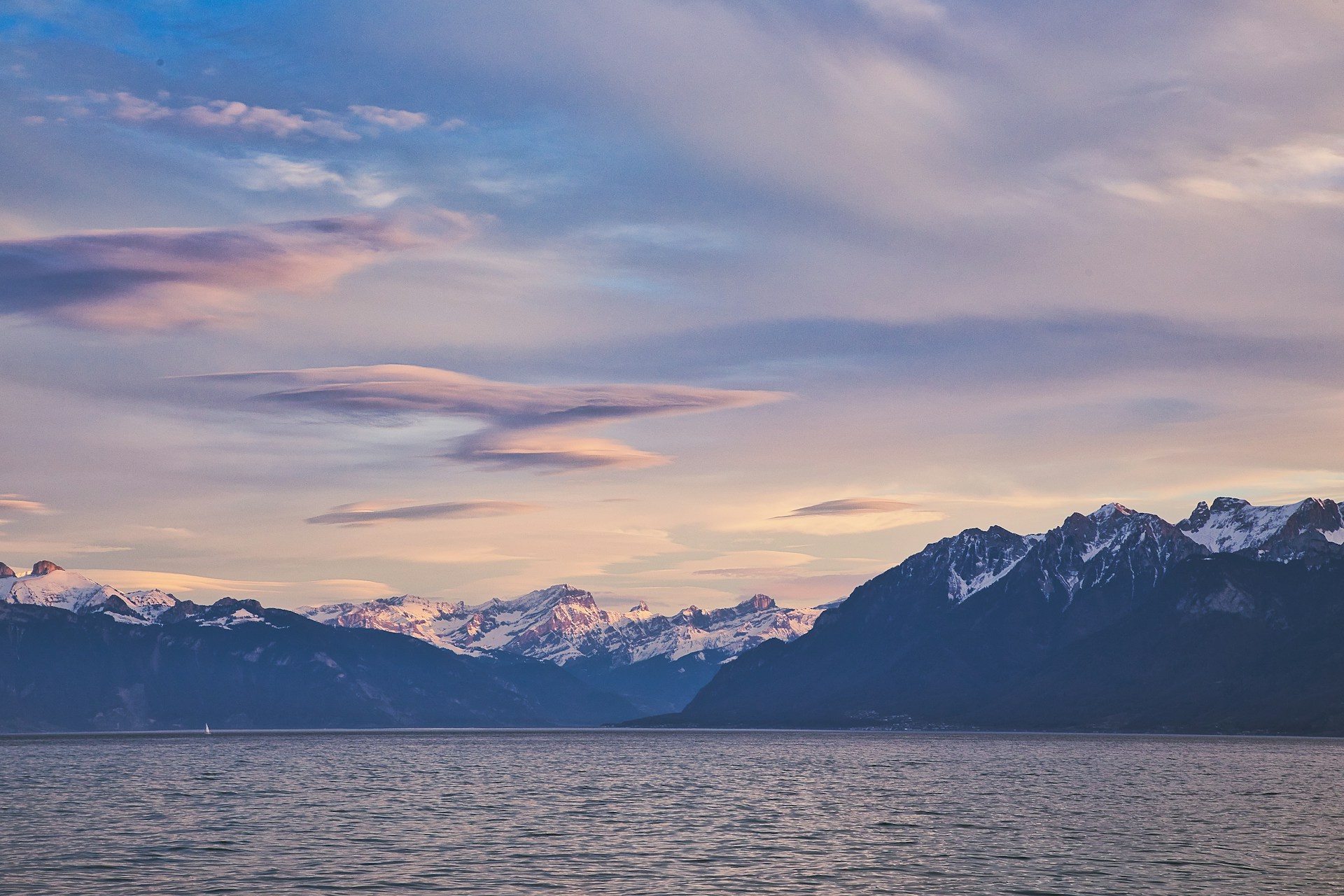 snow covered mountain near body of water during daytime