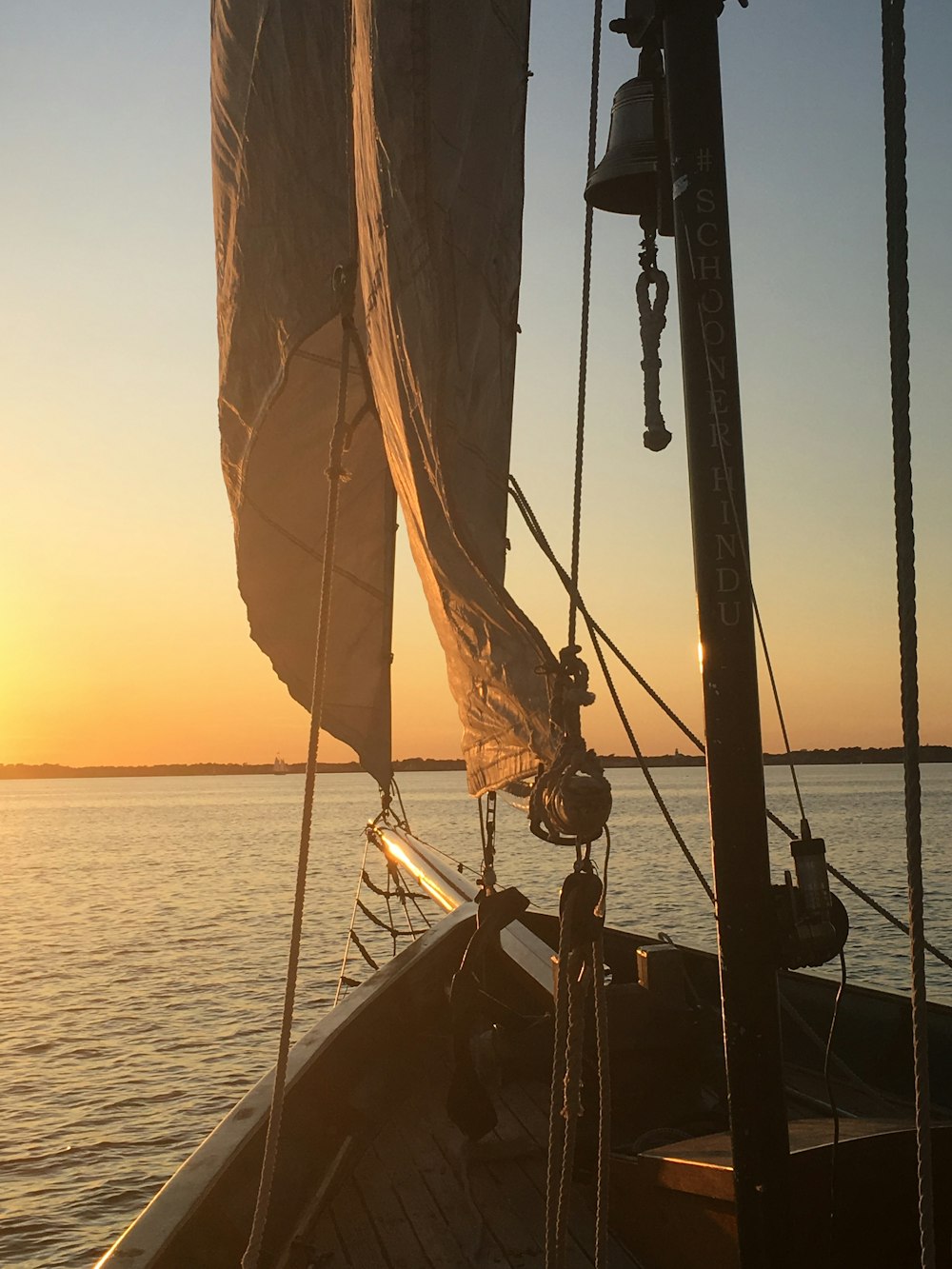Barco marrón y negro en el mar durante la puesta del sol