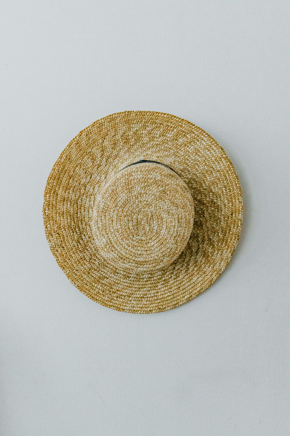 brown round hat on white surface