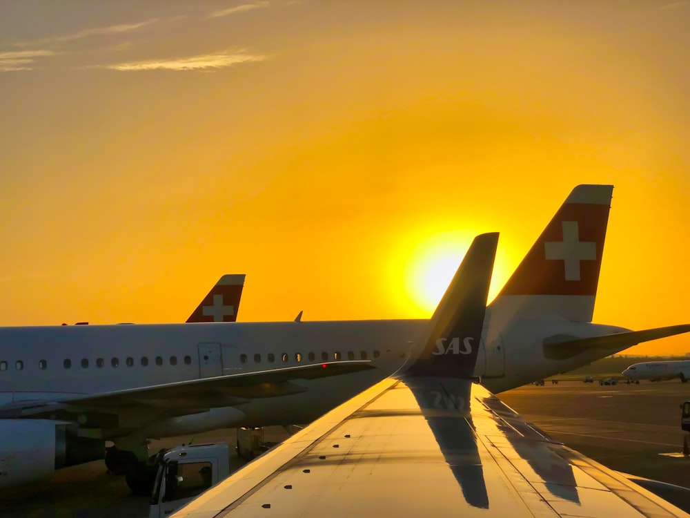 white and blue airplane under yellow sky