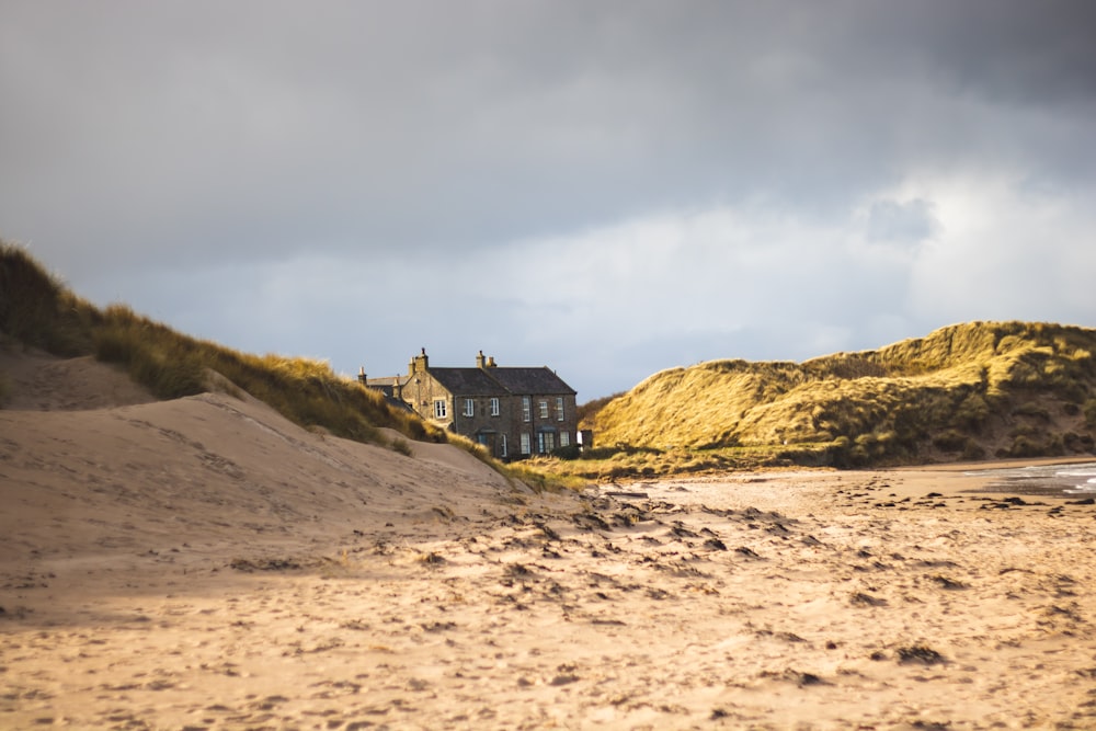 brown and green house on hill under white clouds during daytime