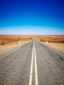gray asphalt road under blue sky during daytime