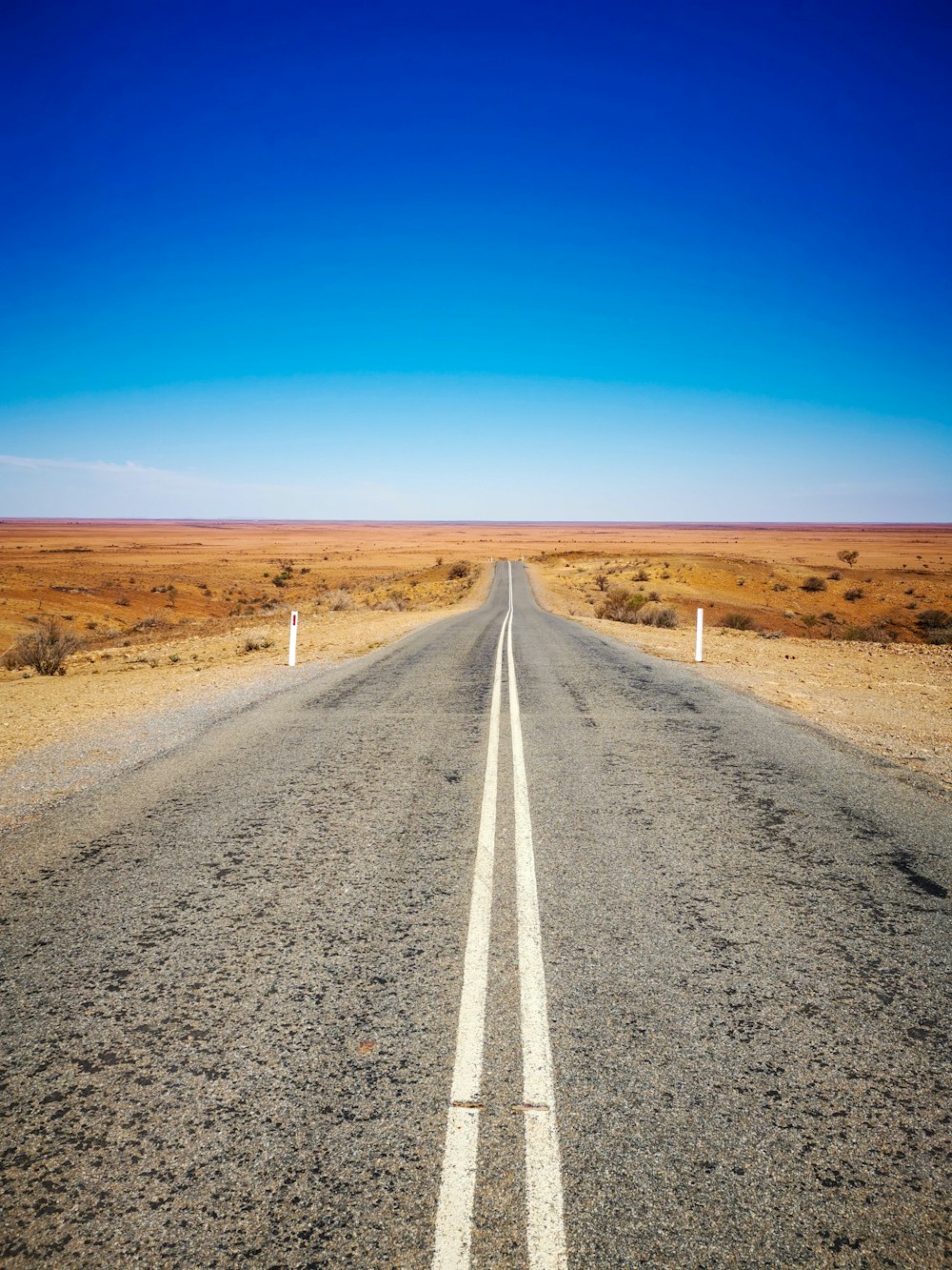 graue Asphaltstraße unter blauem Himmel tagsüber