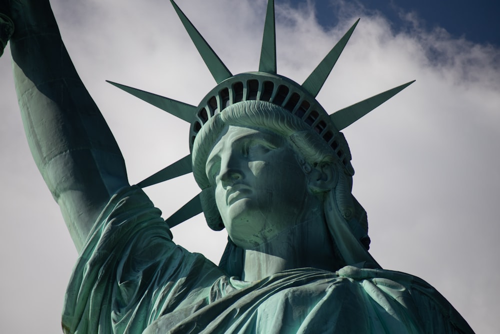 statue of liberty under cloudy sky during daytime