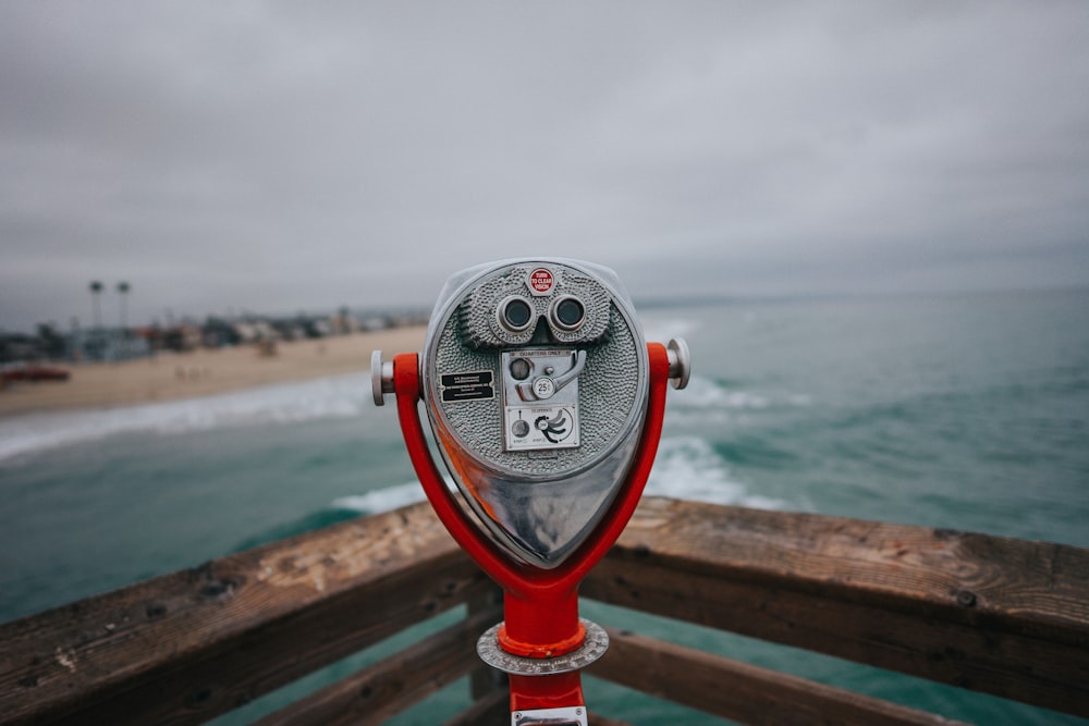 gray and red coin operated telescope